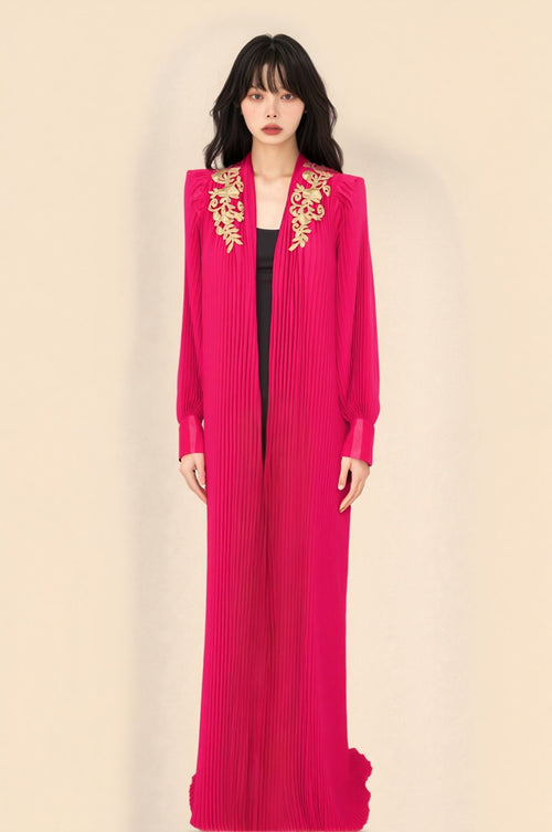 Elegant crimson pleated gown with gold embroidery and structured shoulders, perfect for formal occasions.