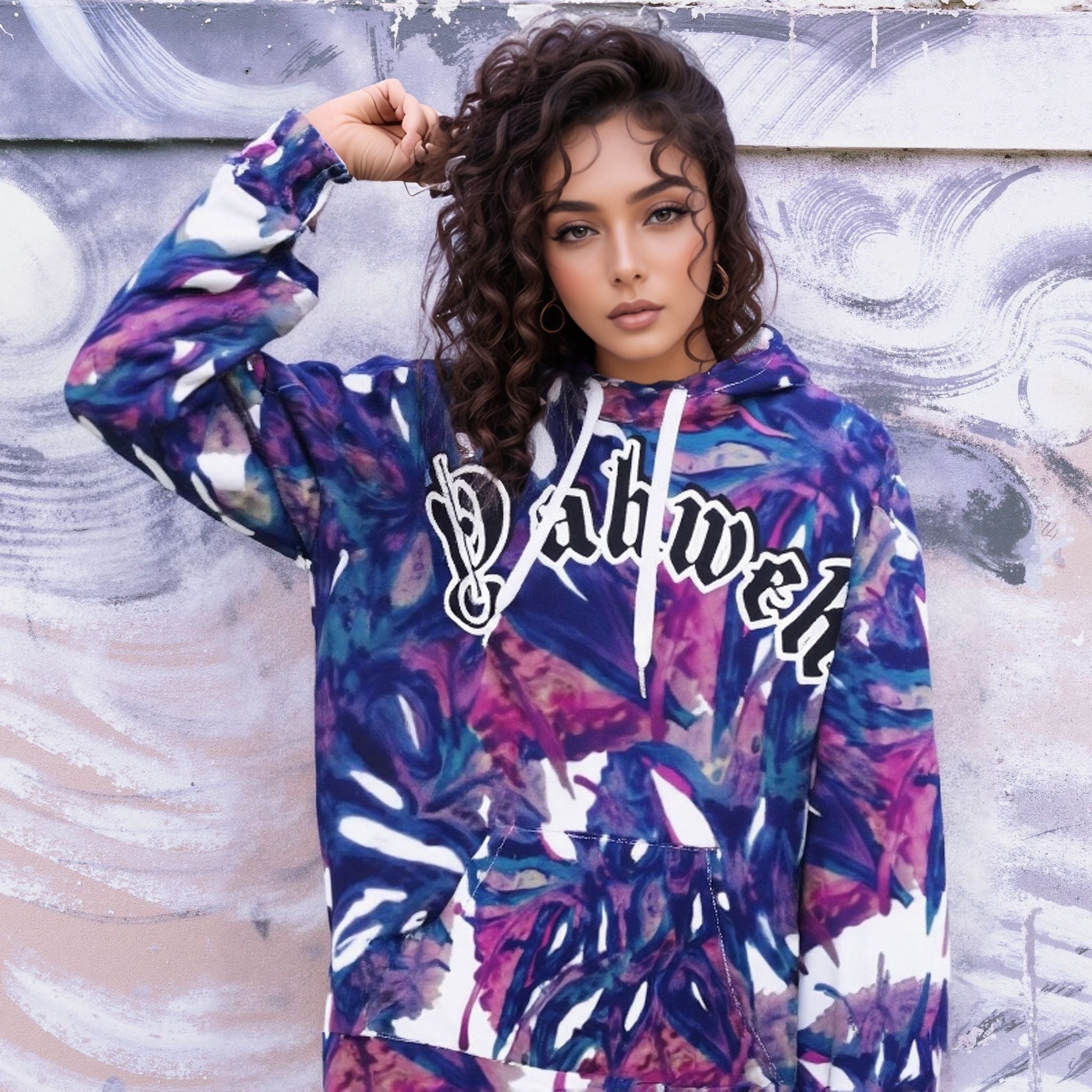 Yahweh Abstract Print Hoodie featuring bold colors and urban elegant design, worn by model against artistic backdrop.