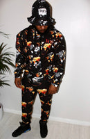 Man wearing Ember Blaze Men’s Hoodie with vibrant print, styled with a matching outfit and bucket hat.