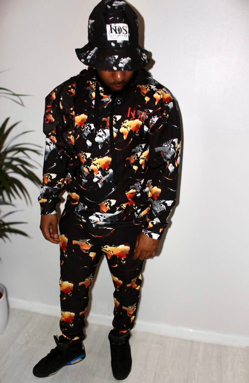 Man wearing Ember Blaze Men’s Hoodie with vibrant print, styled with a matching outfit and bucket hat.