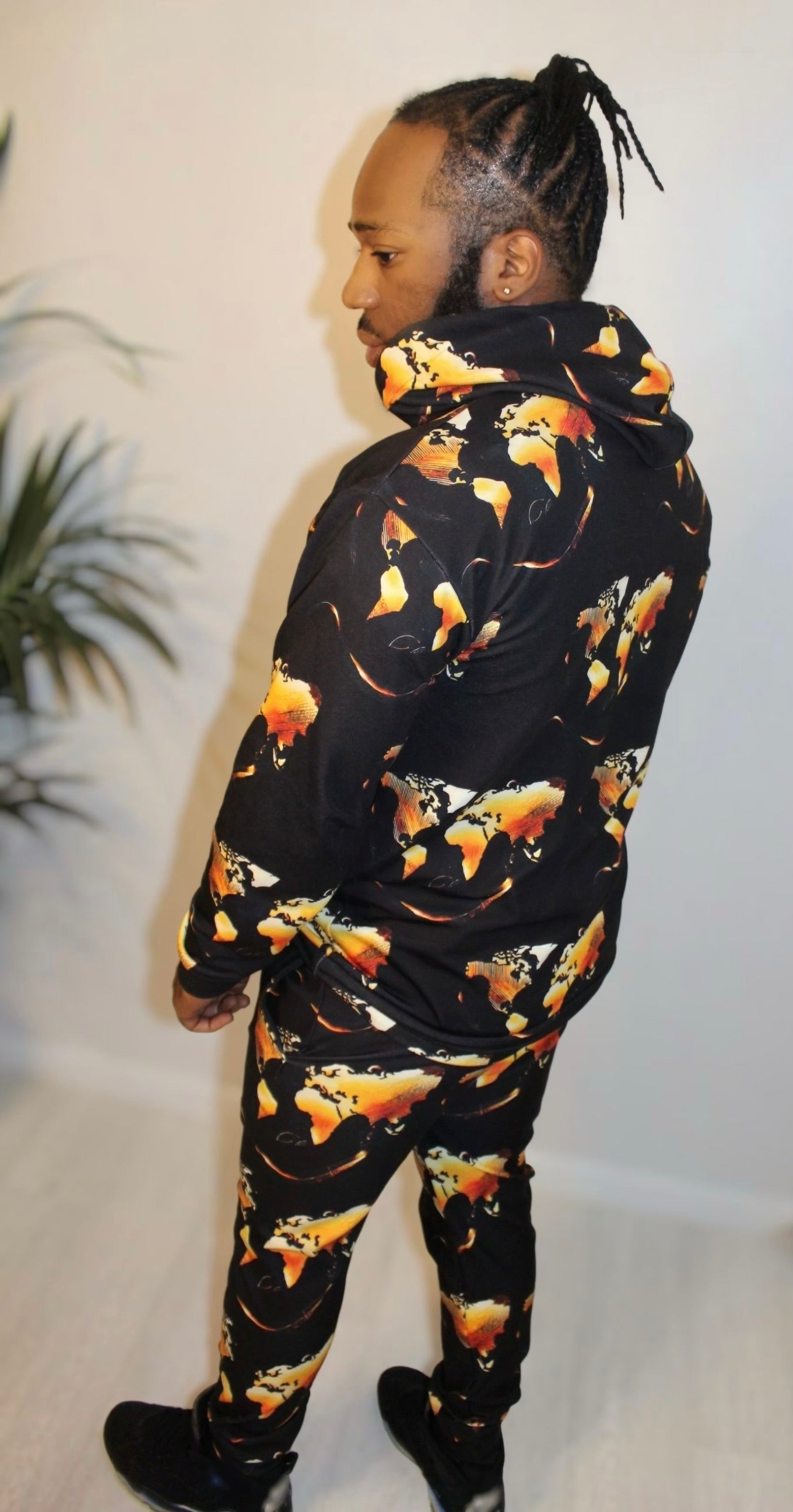 Man wearing Midnight Flame Hoodie with bold abstract world map print, showcasing urban elegance and comfort.