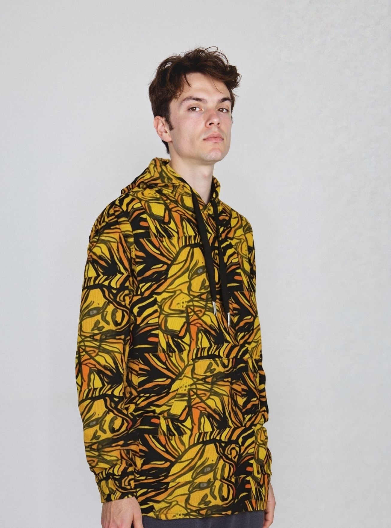 A model wearing the Lion Ember Crown hoodie with a bold yellow and black patterned design.