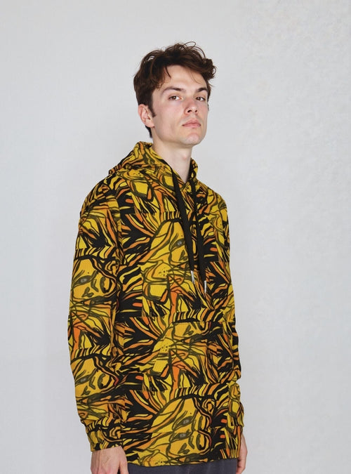 A model wearing the Lion Ember Crown hoodie with a bold yellow and black patterned design.