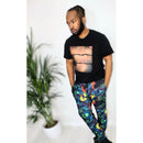 Urban Peacock Mirage Joggers featuring vibrant geometric print, styled with a black tee, in a modern urban setting.
