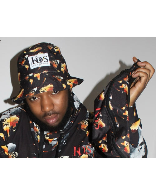 Man wearing Ember Blaze Reversible Bucket Hat with vibrant print design and matching jacket, showcasing stylish streetwear.