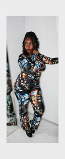 Model showcasing a vibrant, multi-colored artistic print outfit in a stylish pose against a neutral background.
